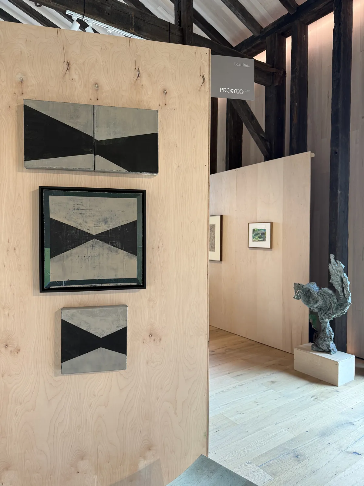 Installation view of the Cold Wax paintings on a plywood wall with the gallery space beyond